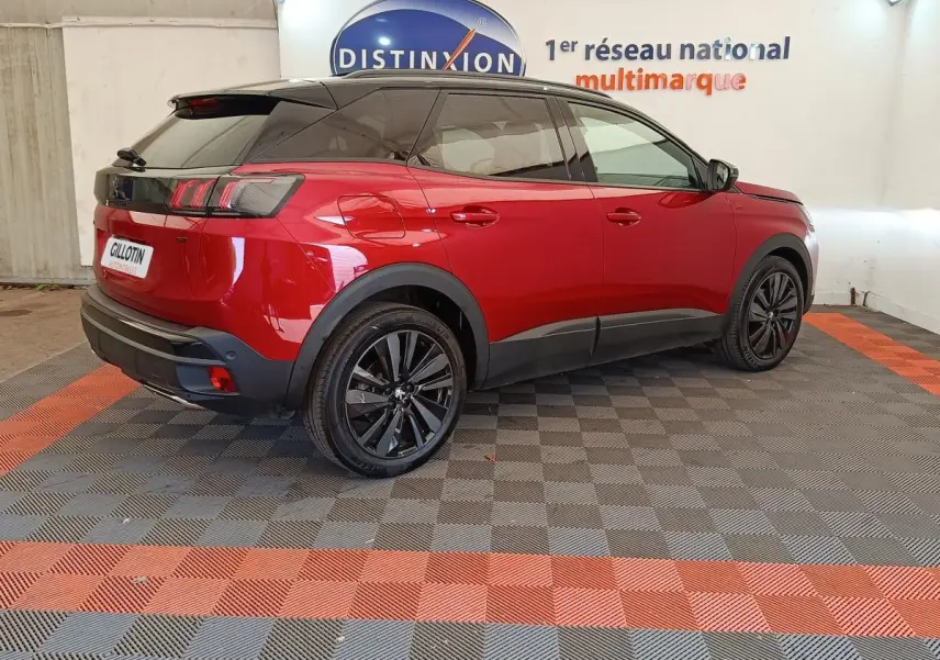Peugeot 3008 rouge vue 3/4 arrière droit, toit noir et jantes alliage noires dans showroom.