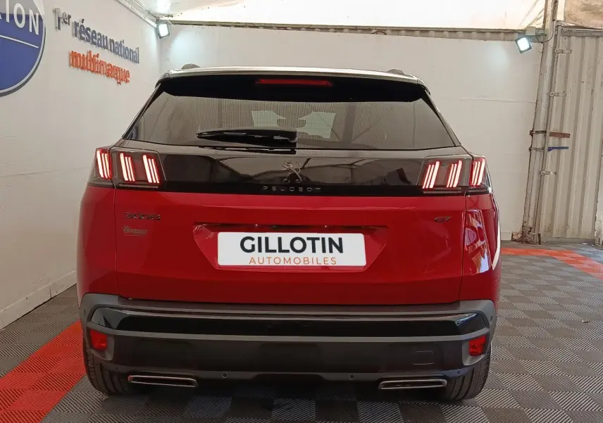 Vue arrière d'un Peugeot 3008 GT Pack rouge avec feux LED caractéristiques et double sortie d'échappement.