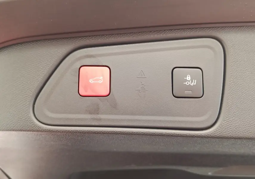 Gros plan sur les boutons de commande de coffre et verrouillage des sièges du Peugeot 3008 GT Pack rouge, intérieur noir.