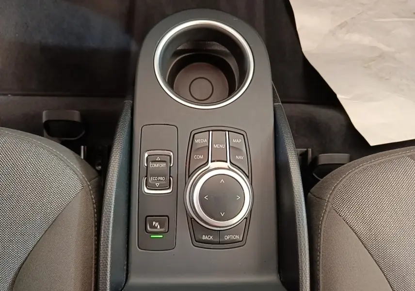 Vue plongeante sur la console centrale noire du BMW i3 120 Ah avec molette de contrôle et boutons de mode de conduite.