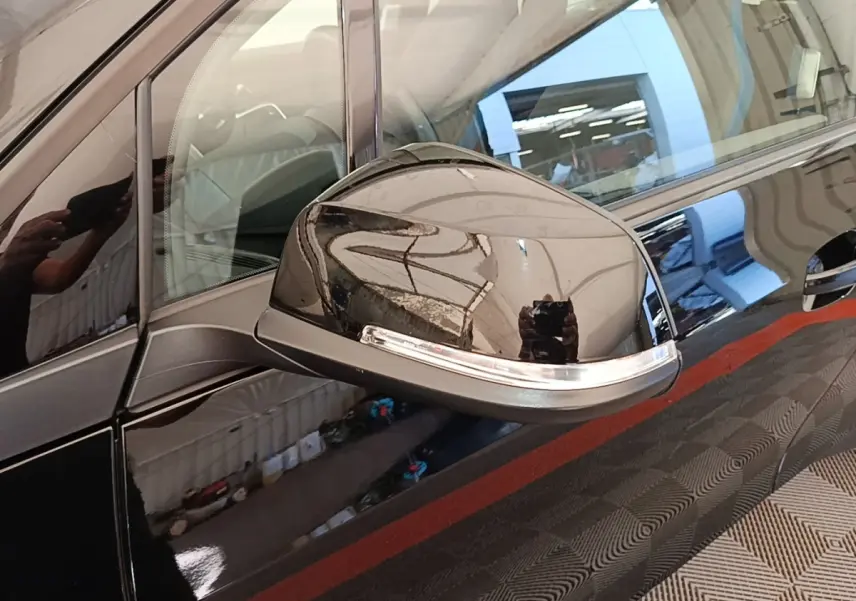 Rétroviseur côté gauche noir brillant de la BMW i3 120 Ah Atelier 2020 avec carrosserie noire réfléchissante.