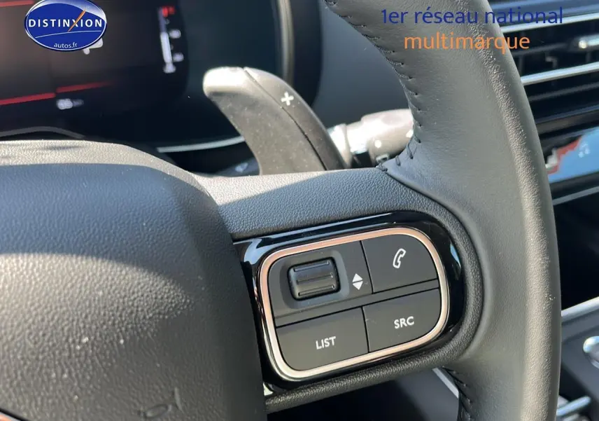 Gros plan sur les commandes au volant du Citroën C5 Aircross 2025 noir, mettant en valeur les boutons de gestion audio et appel.