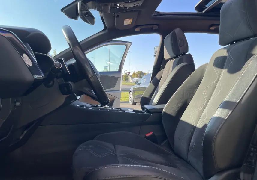 Vue intérieure côté conducteur du DS7 2018, sièges gris noir en alcantara avec toit ouvrant panoramique visible.