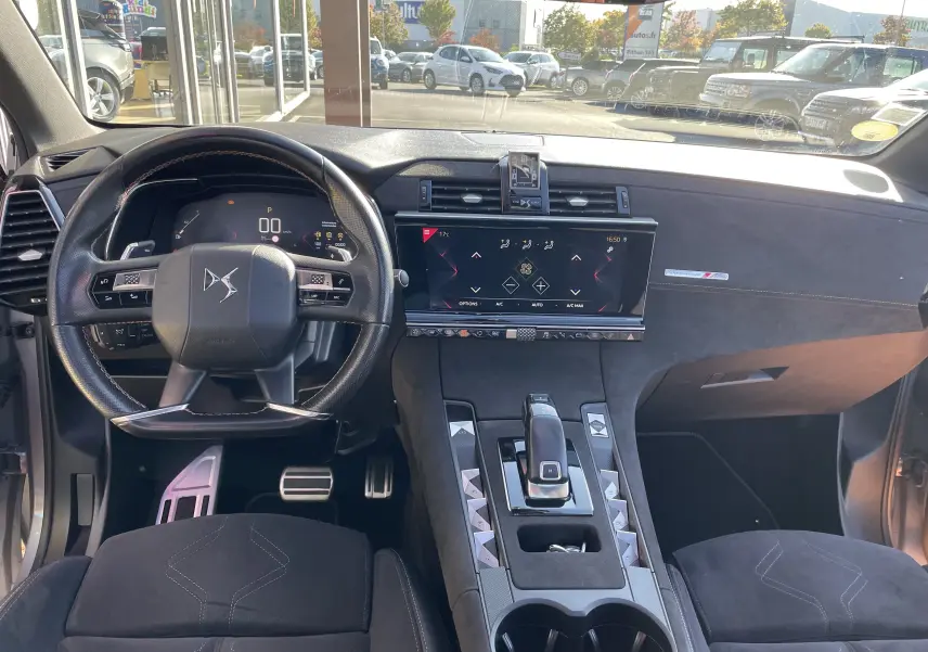Vue intérieure du poste de conduite du DS7 gris Artens, avec volant multifonction, écran tactile central et finitions en alcantara noir.