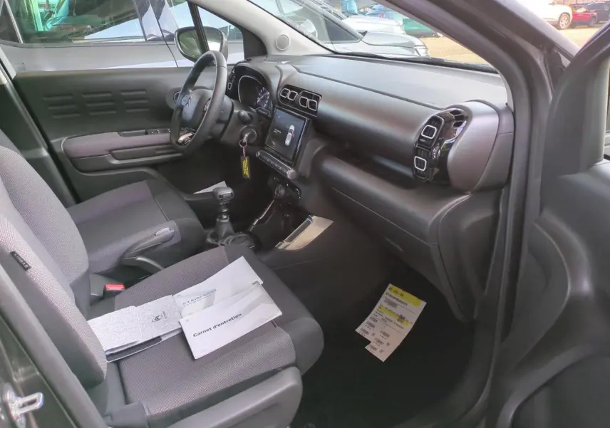 Intérieur côté conducteur du Citroën C3 Aircross gris foncé, montrant tableau de bord et sièges tissu Mica Grey.