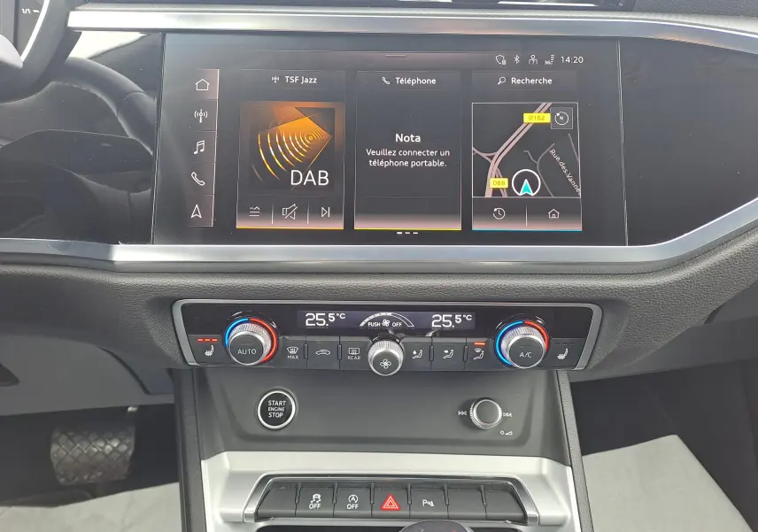 Vue rapprochée de la console centrale de l'Audi Q3 gris nano 2023 avec écran tactile et commandes climatisation.