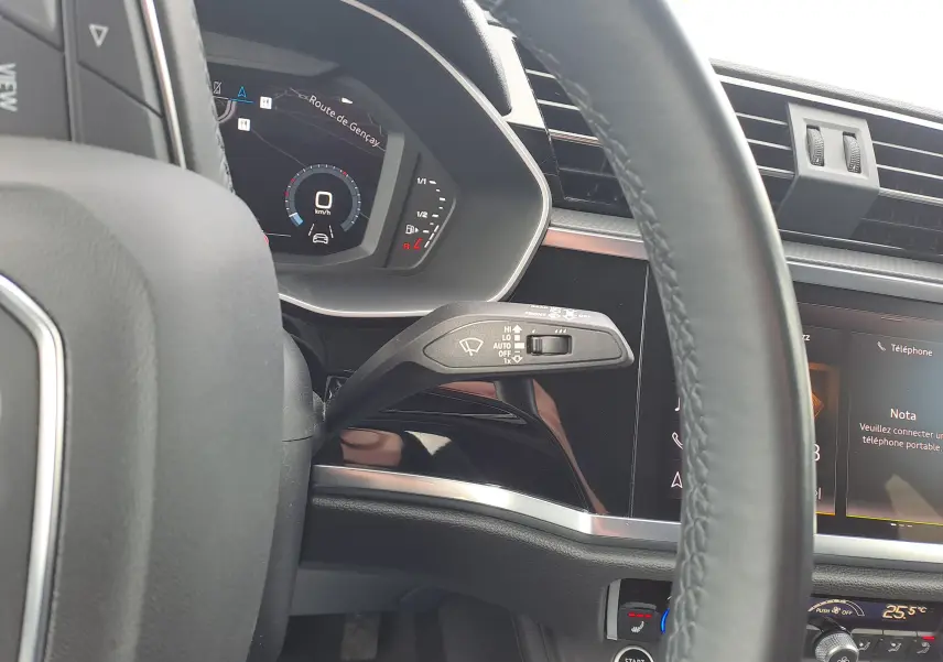 Vue rapprochée du tableau de bord et volant côté gauche de l’Audi Q3 35 TDI gris Nano avec écran digital et commandes intégrées.