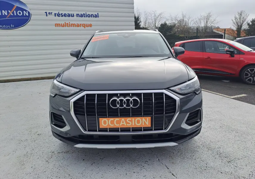 Vue frontale d'un Audi Q3 gris nano 2023 avec calandre large et plaque "OCCASION" orange visible.