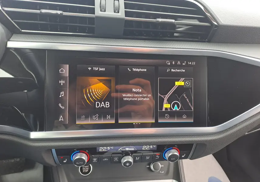 Vue rapprochée de l’écran tactile central et de la console de climatisation de l’Audi Q3 35 TDI gris nano 2023.