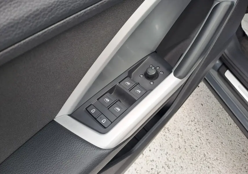Gros plan sur les commandes des vitres et rétroviseurs côté conducteur d’un Audi Q3 gris nano 2023.