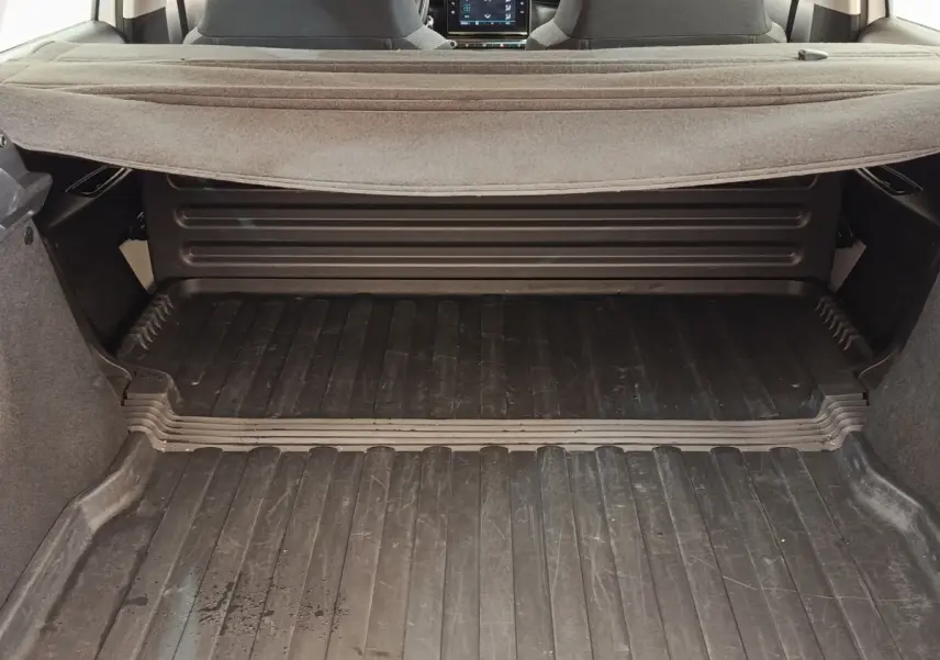 Vue du coffre ouvert d'une Citroën C3 blanche 2022, avec plancher caoutchouté et tablette arrière relevée.
