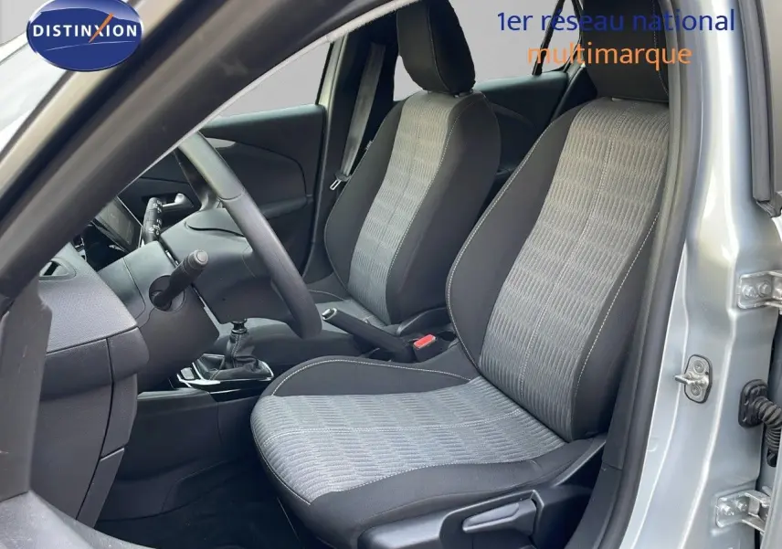Intérieur avant droit de l'Opel Corsa gris Kristall Metal 2022, sièges tissu bi-ton et boîte manuelle visible.