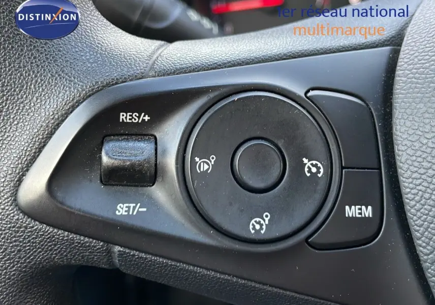 Gros plan sur les commandes de régulateur de vitesse au volant d'une Opel Corsa gris kristall metal 2022.