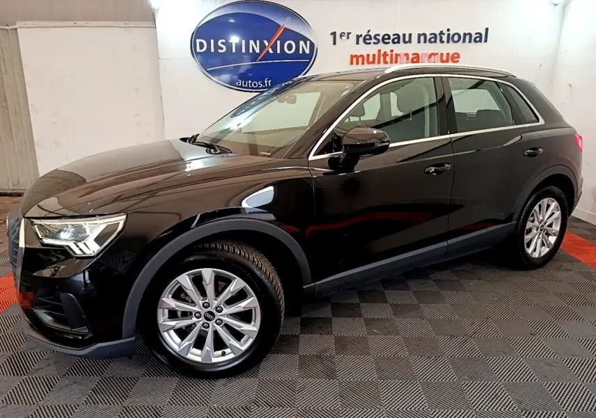Audi Q3 35 TDI noir vue de profil côté gauche dans un showroom avec logo Distinxion en arrière-plan.