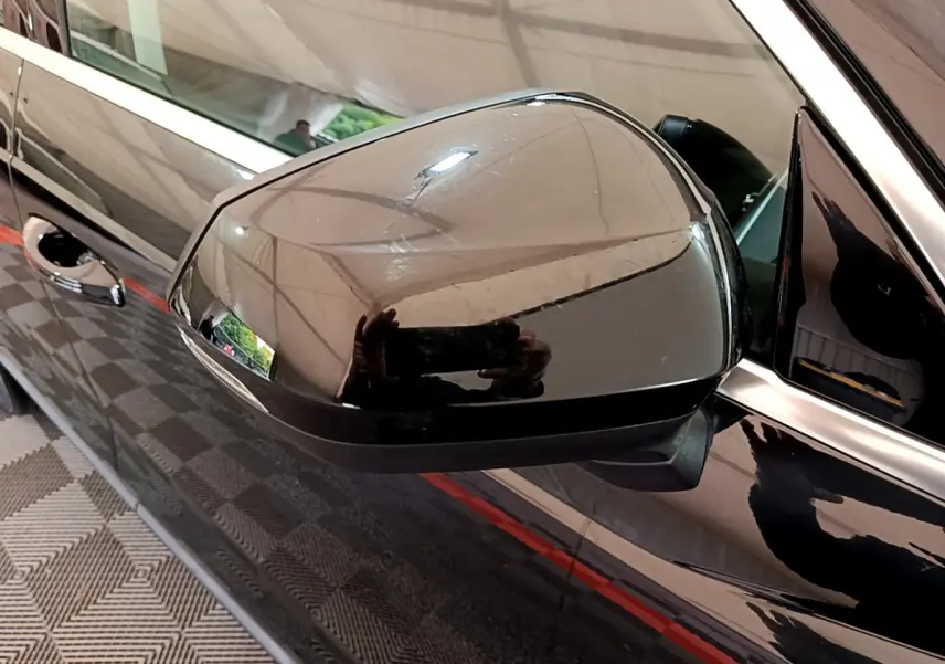 Rétroviseur côté conducteur noir brillant d'un Audi Q3 35 TDI 2021 avec carrosserie noire et poignées chromées.