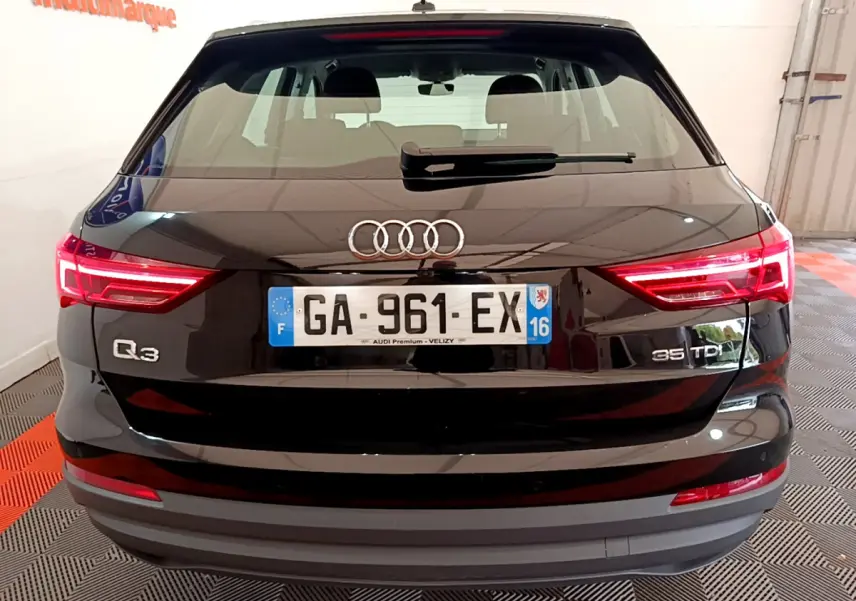 Vue arrière d'un Audi Q3 35 TDI noir avec feux LED allumés et plaques d'immatriculation françaises visibles.