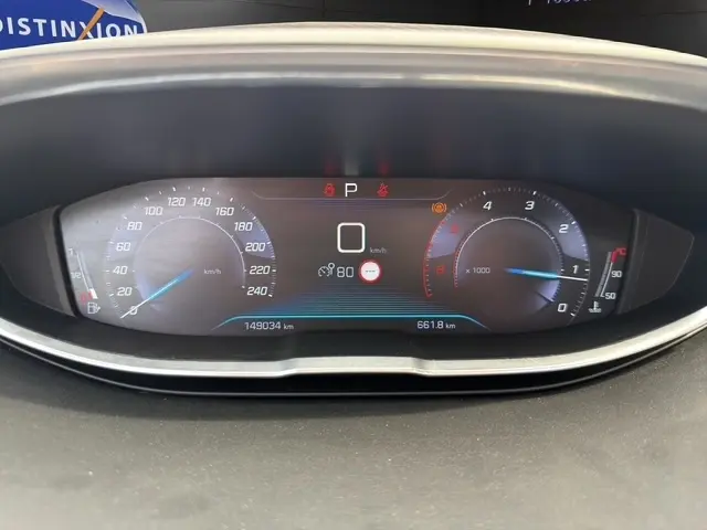 Vue rapprochée du tableau de bord de la Peugeot 208 gris platinium, affichant le compteur et l'écran digital central.