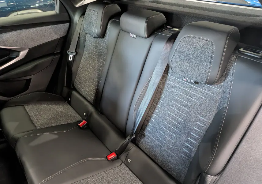 Vue intérieure des sièges arrière en cuir noir et tissu gris du Peugeot 3008 Hybrid 2026, côté gauche visible.
