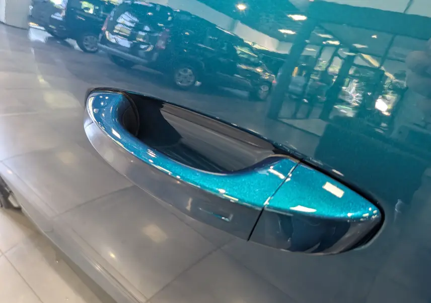 Gros plan sur la poignée de porte côté gauche du Peugeot 3008 Hybrid 145 CH e-DCS6 Allure en Bleu Obsession métallisé.