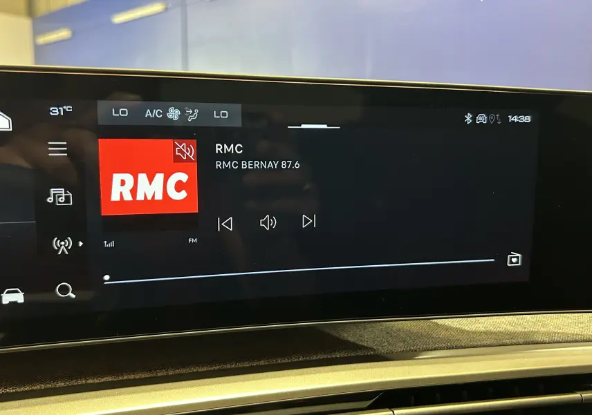 Écran tactile central du Peugeot 3008 III Hybrid blanc, affichant la radio RMC en mode muet, intérieur moderne.