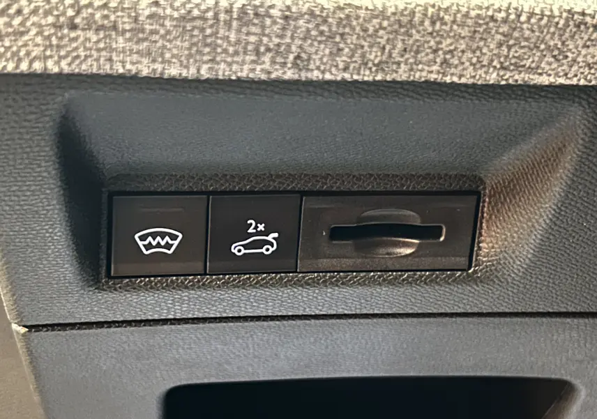 Gros plan sur les boutons de commande du hayon et du dégivrage arrière dans un Peugeot 3008 blanc Okenite.