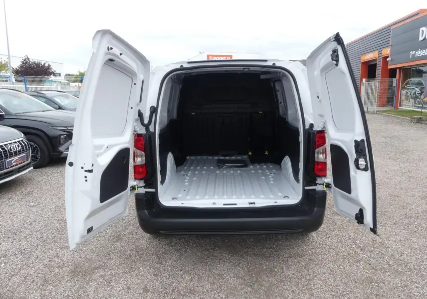 Vue arrière du Peugeot Partner blanc 2025 avec portes battantes ouvertes dévoilant l'espace de chargement vide.