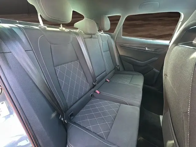 Vue intérieure côté droit des sièges arrière noirs en tissu avec surpiqûres croisées du Skoda Karoq 2025 Sportline.