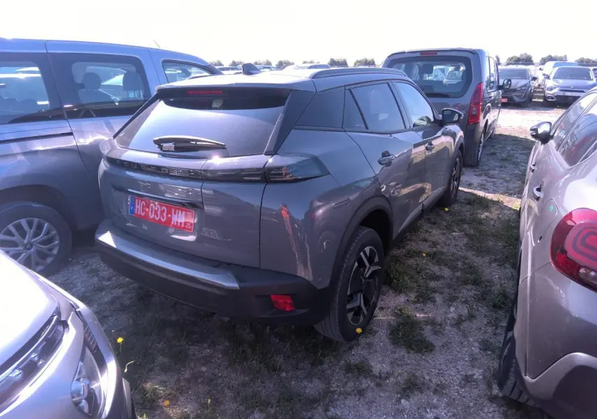 Peugeot 2008 gris clair vue 3/4 arrière droit, avec feux arrière LED et jantes alliage noires.