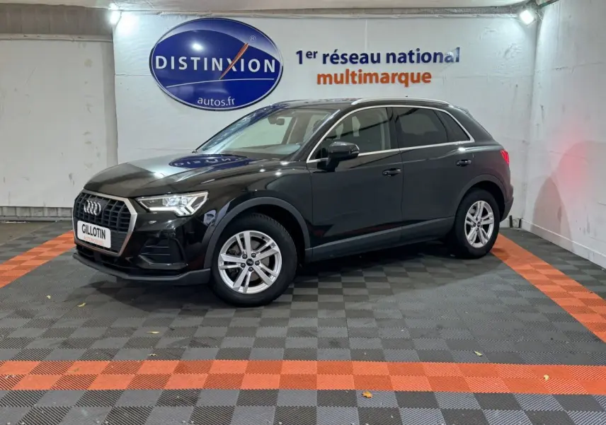 Audi Q3 noir vue 3/4 avant droit en intérieur avec jantes argentées et logo Distinxion en arrière-plan