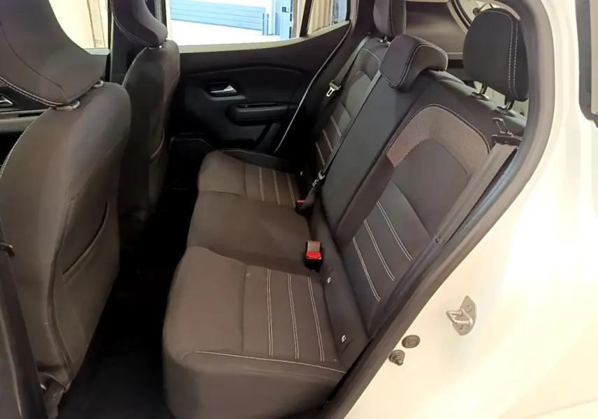 Vue intérieure côté droit sur la banquette arrière noire de la Dacia Sandero Confort TCe 90 blanche de 2022.