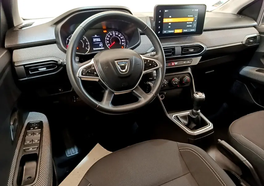 Vue intérieure avant de la Dacia Sandero Confort TCe 90 2022, tableau de bord avec écran tactile et volant multifonctions.