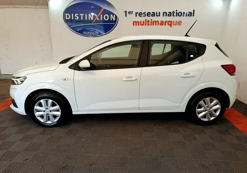 Vue de profil côté gauche d'une Dacia Sandero blanche 2022, avec jantes alliage et feux arrière LED visibles.