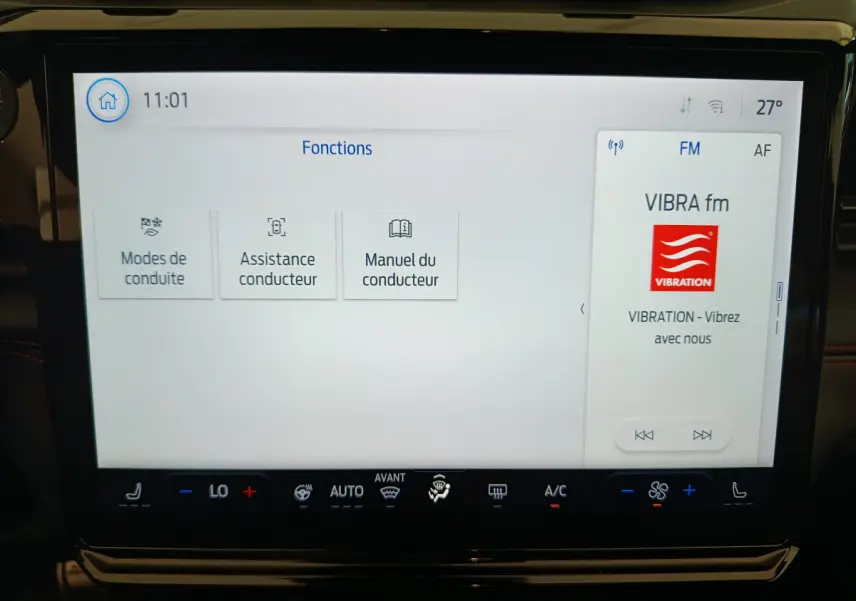 Écran tactile central du Ford Puma 2025 affichant les fonctions de conduite et la radio VIBRA fm en intérieur noir.