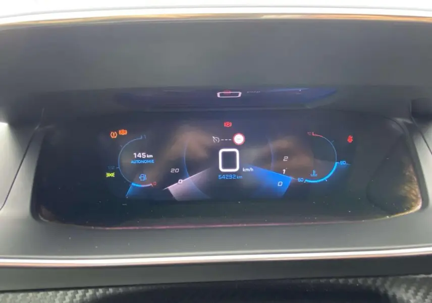 Tableau de bord numérique de Peugeot 208 1.2i PureTech 2020 affichant vitesse à zéro et autonomie 145 km.