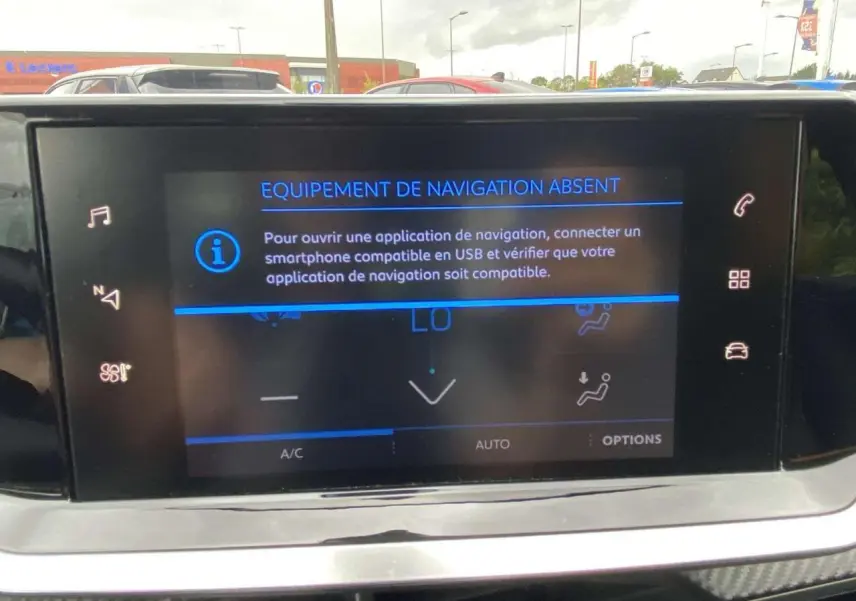 Écran tactile central de la Peugeot 208 bleu 2020 affichant un message d'absence d'équipement de navigation.