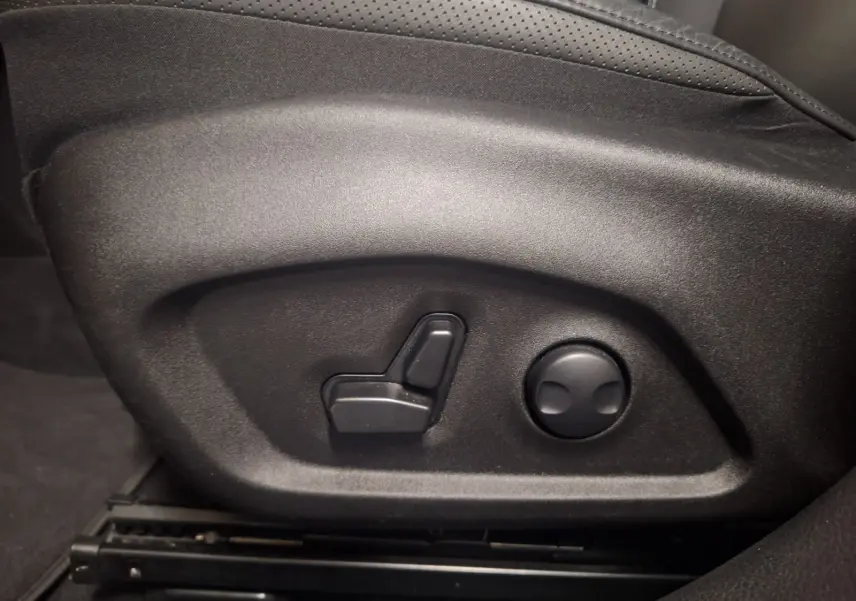 Commandes électriques de réglage du siège en cuir noir dans un Jeep Renegade 2024 hybride.