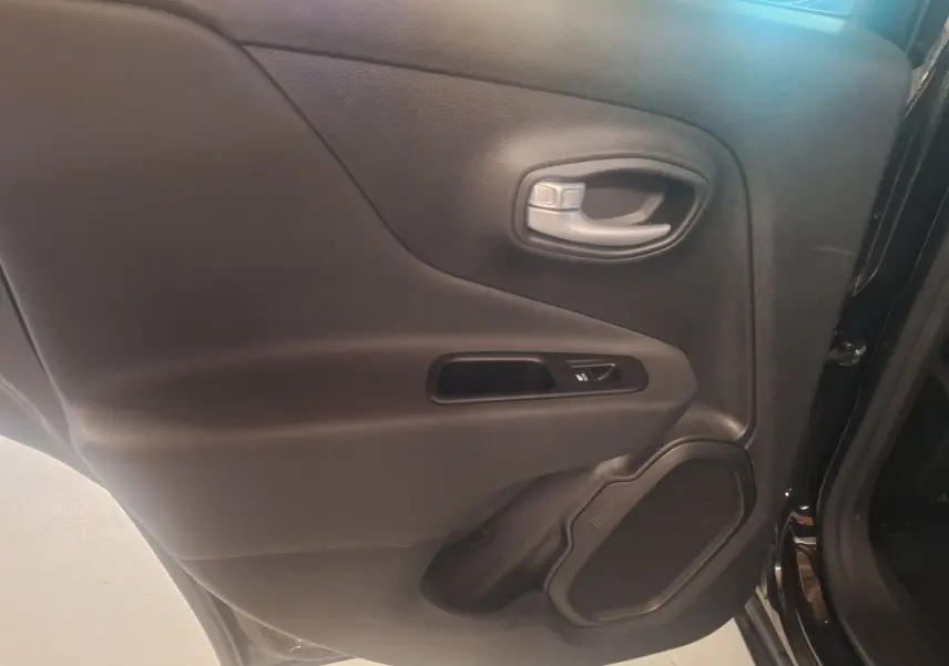 Gros plan sur la porte arrière côté gauche noire du Jeep Renegade 2024 avec poignée et haut-parleur intégrés.