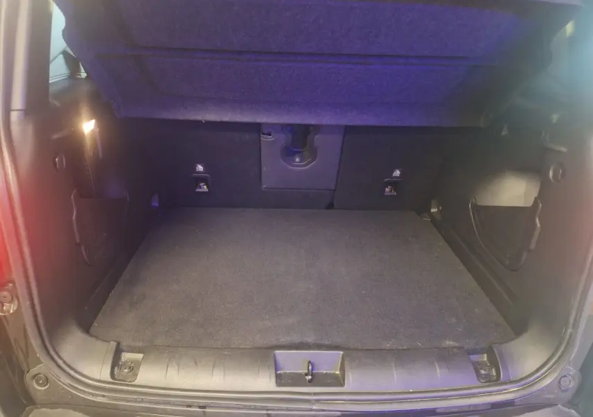 Coffre ouvert d'un Jeep Renegade noir 2024, montrant l'espace de chargement vide et l'éclairage intérieur.