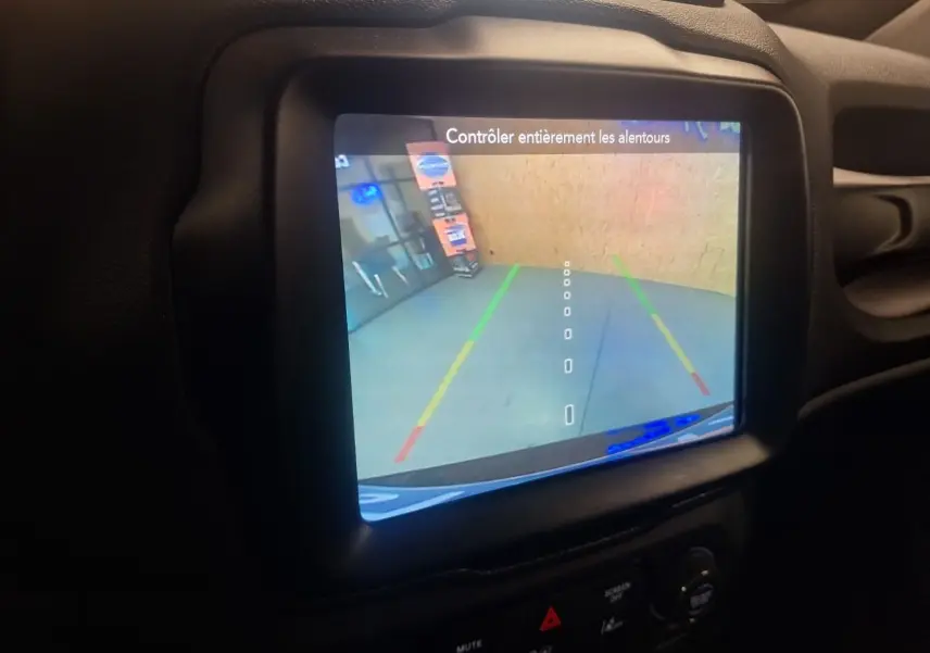 Écran de caméra de recul du Jeep Renegade 2024 affichant les lignes de guidage dans un intérieur noir.