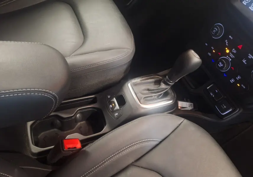 Vue rapprochée de la console centrale et levier de vitesse automatique du Jeep Renegade noir, intérieur cuir noir.