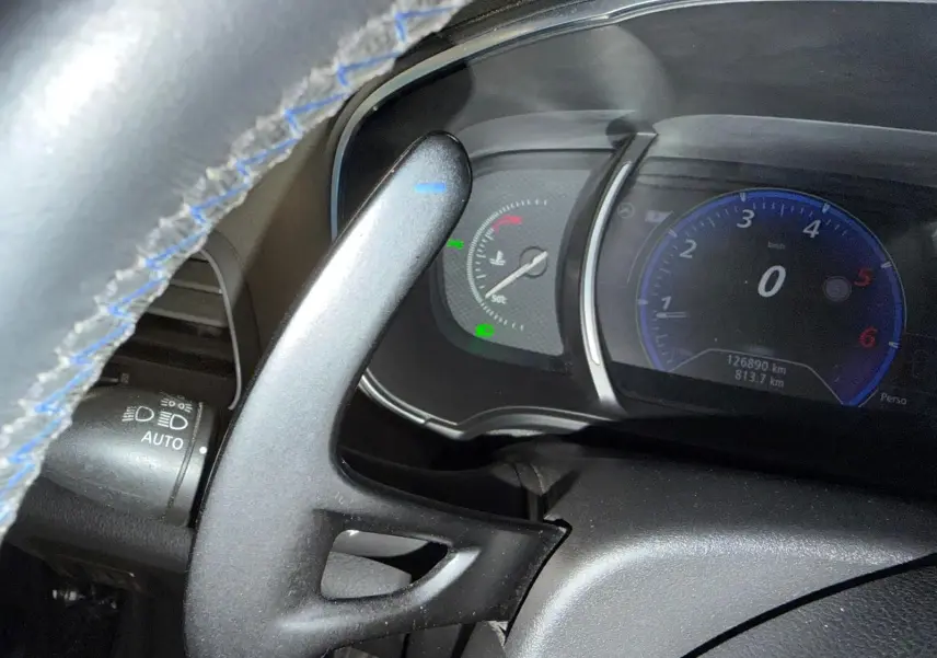 Vue rapprochée du tableau de bord et du volant avec surpiqûres bleues de la Renault Mégane Break GT diesel gris de 2017.