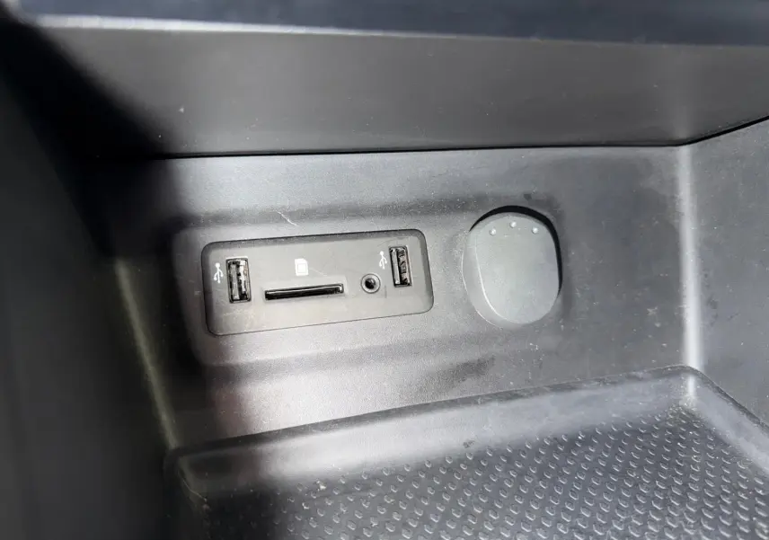 Vue rapprochée du port USB et lecteur carte SD intégré dans la console centrale d’une Renault Mégane Break gris 2017.