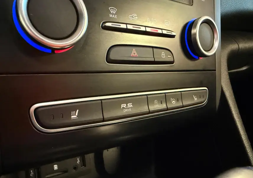 Gros plan sur la console centrale noire de la Renault Mégane Break GT avec commandes de climatisation et bouton R.S. Drive.