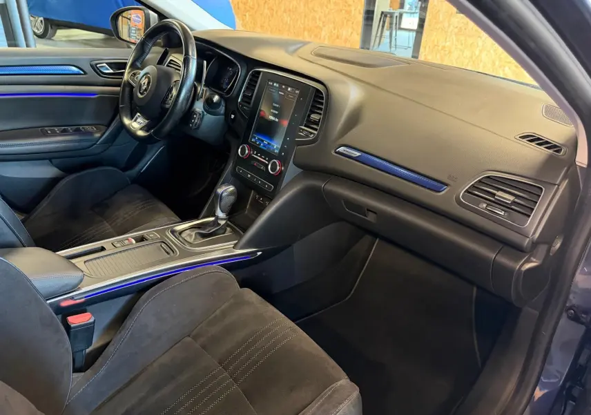 Intérieur avant droit de la Renault Mégane Break GT 2017, avec tableau de bord noir et éclairage d'ambiance bleu.