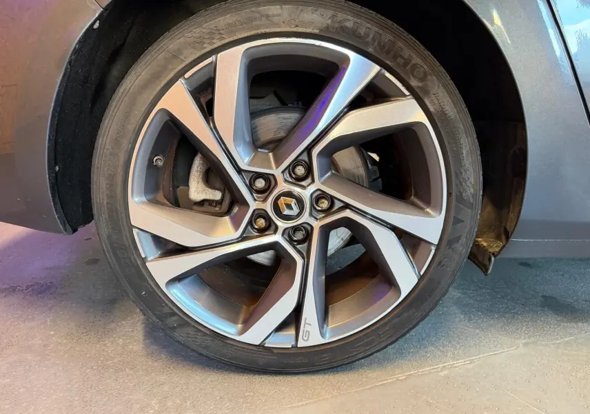 Gros plan sur la roue avant droite gris métallisé d'une Renault Mégane Break GT 2017 avec jante alliage marquée GT.