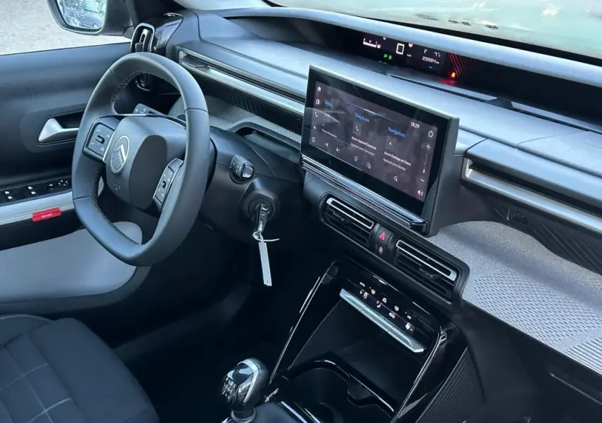 Vue intérieure côté conducteur de la Citroën C3 2025 noire, avec tableau de bord moderne et écran tactile central.