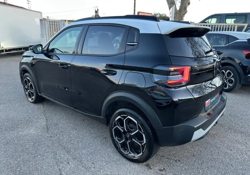 Citroën C3 Turbo 100 ch noir vue 3/4 arrière droit, jantes alliage 17 pouces et barres de toit visibles.