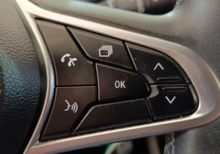 Gros plan sur les commandes multifonctions noires du volant en cuir synthétique d’une Renault Clio Business Blue dCi 100 2022.