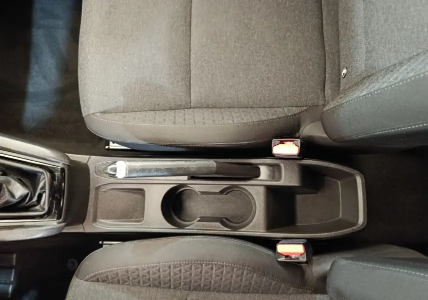 Vue plongeante sur la console centrale noire entre les sièges avant tissu gris foncé de la Renault Clio Business Blue dCi 100.