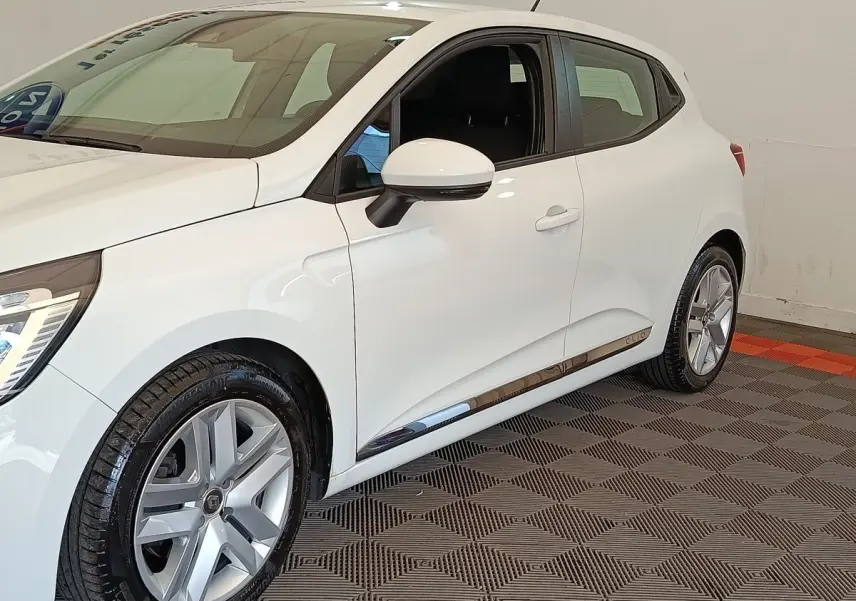 Vue 3/4 avant droit d'une Renault Clio Business Blue dCi 100 blanche avec jantes alliage et rétroviseurs assortis.